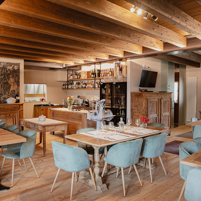Interno del ristorante la tàula de m’aura con arredi in legno e atmosfera tipica della Valle Maira